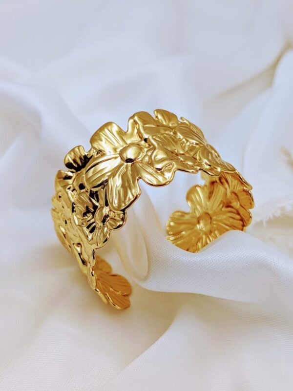 Jhunkaar Golden Floral Cuff Bracelet on a silk fabric