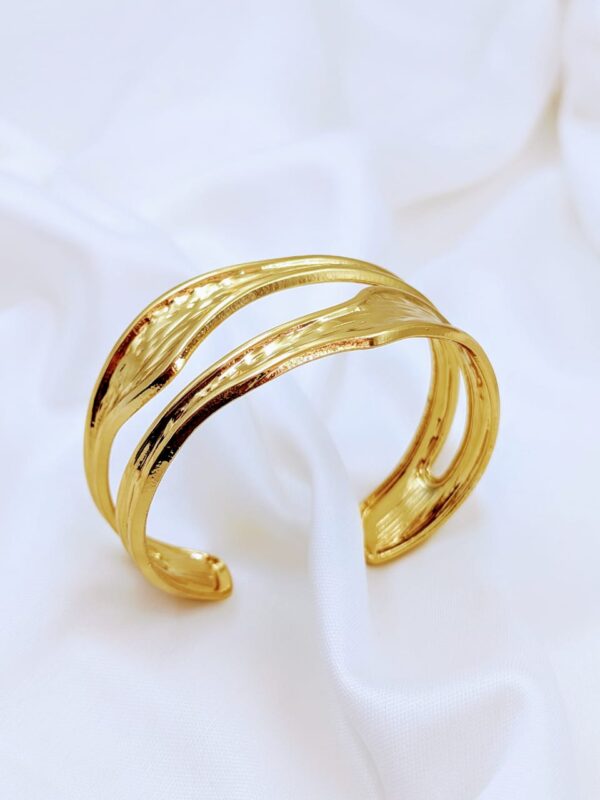 Introducing our stunning gold wide cuff bracelets, designed to make a statement with their bold and chunky silhouette. These eye-catching accessories are perfect for elevating any outfit, whether you're dressing up for a special occasion or adding flair to your everyday look. With their striking design, these bracelets effortlessly blend style and elegance, making them a must-have addition to your jewelry collection. Embrace the art of accessorizing and let these cuffs be the focal point of your ensemble!